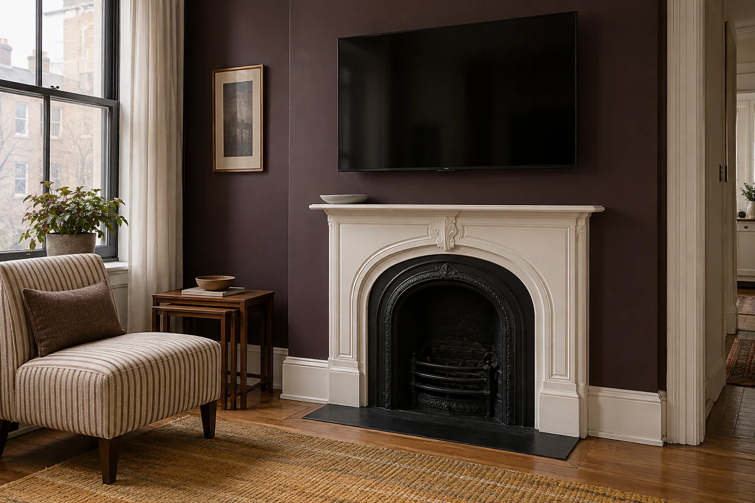 One small gray dish on a shallow white mantel beneath a TV against an aubergine apartment wall, beside a striped chair.